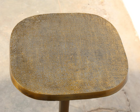 Multipurpose space saving cast aluminum side table in textured brass finish top detail.