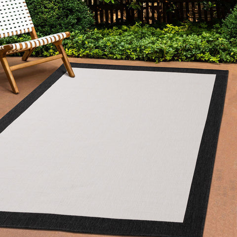 Bristol Reversible Indoor / Outdoor Rug - Cream with Black Border in outdoor setting