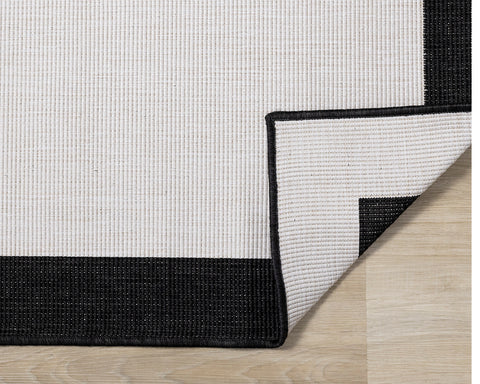 Bristol Reversible Indoor / Outdoor Rug - Cream with Black Border corner flipped to show underside