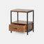 Solid acacia wood nightstand in honey brown finish with industrial black metal frame. Drawer open to show detail.