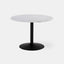 Round dining table with white marble top and black metal pedestal base.