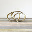 Iron sculpture in gold finish, resembling ribbon intertwined into 3 circles.