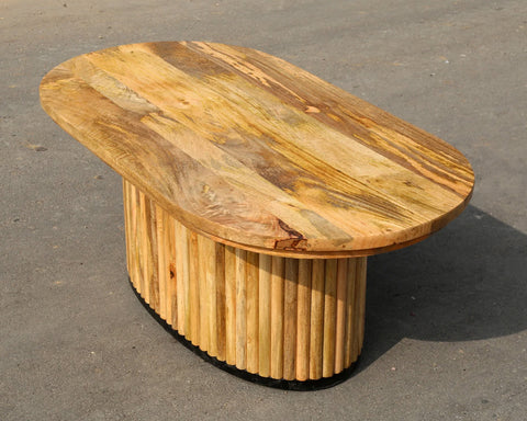 Solid mango wood oblong coffee table with repeating pattern ribbing base in natural finish.