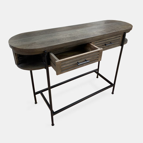 Console table in solid mango wood in dark olive finish with black metal legs and frame showing one drawer open.