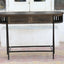 Console table in solid mango wood in dark olive finish with black metal legs and frame.