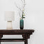  Table lamp with off-white drum shade and white quartz base on table