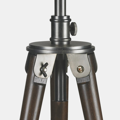  photographer tripod lamp in antique bronze finish with dark brown wood legs. detail of tripod connection to light.