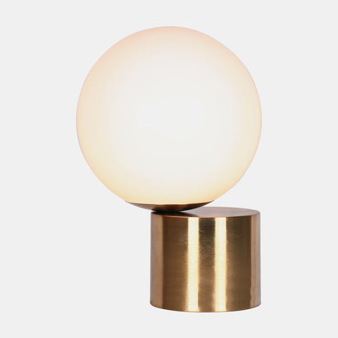 minimal table lamp. Opal glass ball sitting offset on a brushed brass cylinder.
