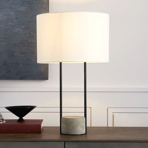 modern industrial concrete and black accent table lamp on a desk in a room setting.