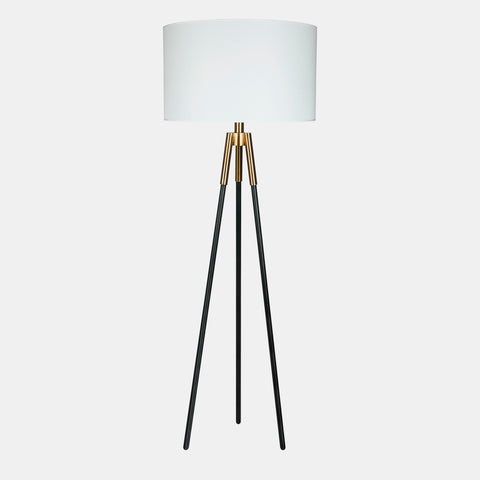Industrial modern tripod floor lamp. White linen shade, black legs and gold accents.