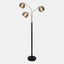 mid-century modern floor lamp with matte black metal base and 3 extended arms featuring metal orb shades in brushed gold.