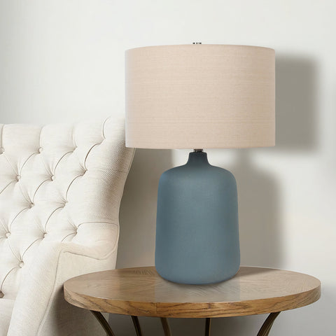  Ceramic Table Lamp with beige drum shade, and blue vase-shaped base in living room on side table