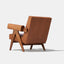 Caramel brown leather lounge chair with leather armrests and solid ash wood legs stained walnut.