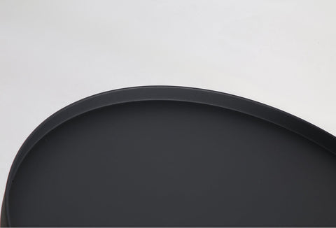 Minimal black powder coated aluminum side table resembling a pier bollard with a black marble base. Top detail.