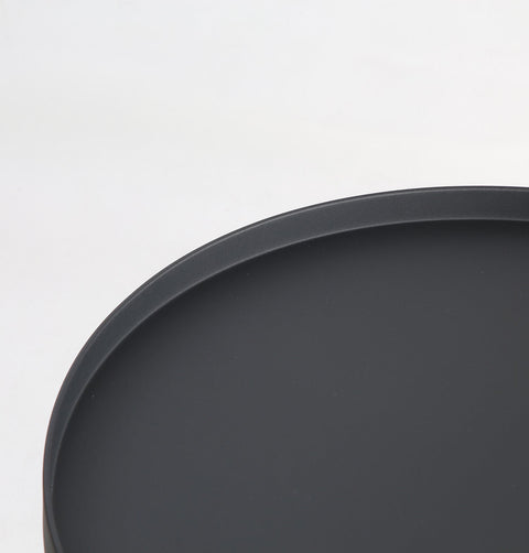 Minimal black powder coated aluminum side table resembling a pier bollard with a black marble base. Top detail.
