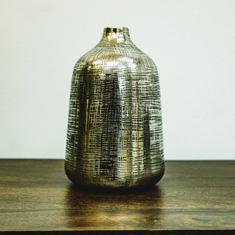 Aluminum bottle shaped vase in silver finish with small opening.