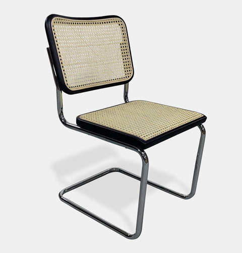 Modern side chair with a natural rattan seat and back framed in black beech wood, sitting on tubular chrome plated cantilevered steel legs. 