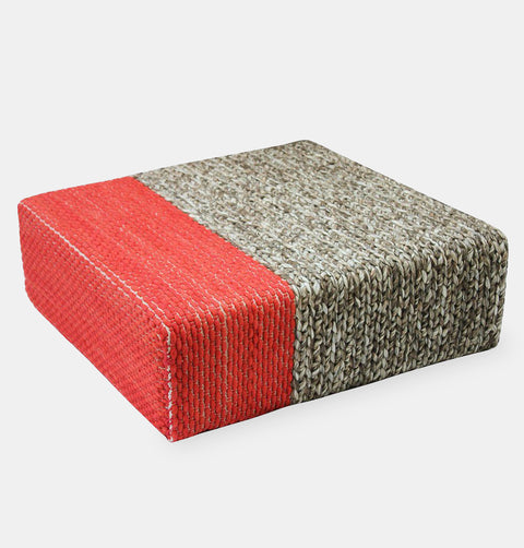 Handmade wool braided square floor pouf in natural grey with offset coral braiding.
