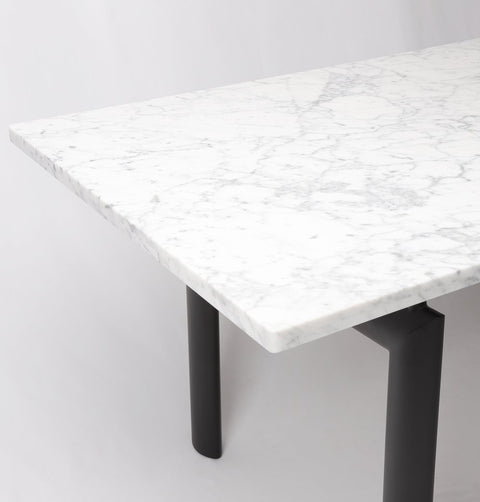 Dining table with Carrara marble top and black metal legs, marble detail.