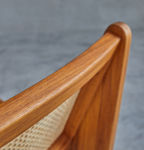 Lounge chair in walnut stained ash wood frame with natural rattan seat and back. Frame detail