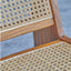 Lounge chair in walnut stained ash wood frame with natural rattan seat and back. Inside corner detail.