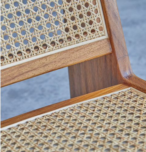 Lounge chair in walnut stained ash wood frame with natural rattan seat and back. Inside corner detail.