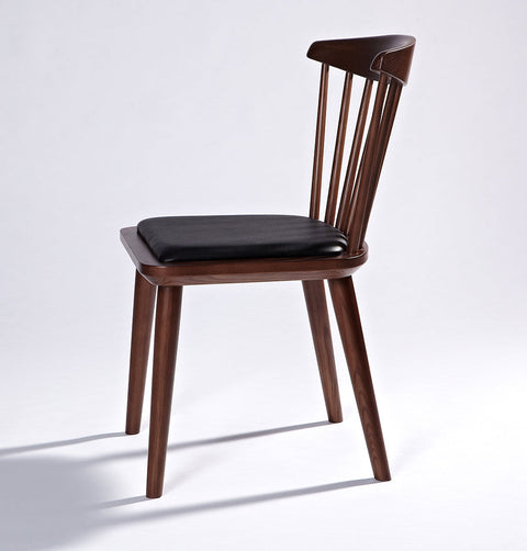 Solid ash wood dining chair in walnut stain finish and black leather seat.