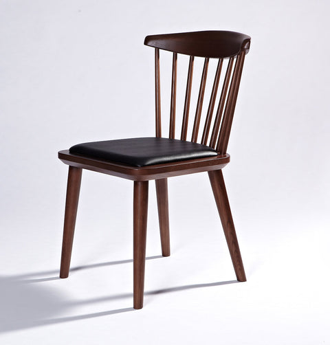 Solid ash wood dining chair in walnut stain finish and black leather seat.