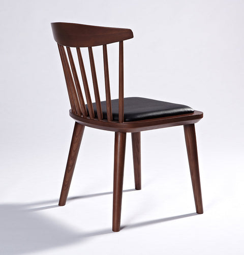 Solid ash wood dining chair in walnut stain finish and black leather seat.