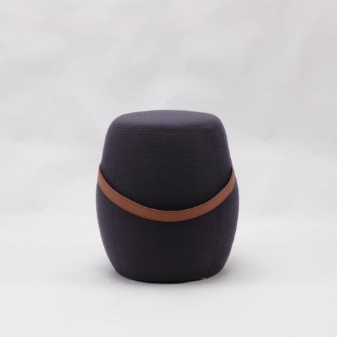 Portable dark grey cashmere pouf / stool with a brown synthetic leather strap handle.