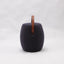 Portable dark grey cashmere pouf / stool with a brown synthetic leather strap handle.